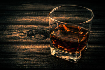 Glass of brandy and on an old wooden table. Close up view