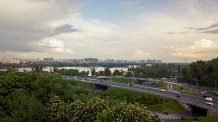 Obraz premium Bird's-eye view of the road and river. summer blooming chestnut Ukraine, Kiev May 18, 2021
