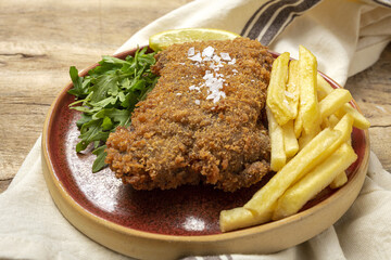 Homemade traditional Milanese veal escalope with french fries
