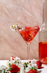 Splash of strawberry cocktail in martini glass