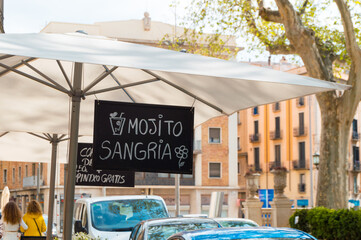 Offer of mojito and sangria on a hanging blackboard of a Spanish bar in the city of Figueres....