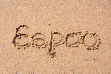 Word Espoo handwritten on a sandy beach