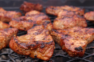 Grilled, brown meat steaks on charcoal
