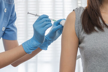 Covid-19,coronavirus hand of young woman nurse,doctor giving syringe vaccine, inject shot to asian...