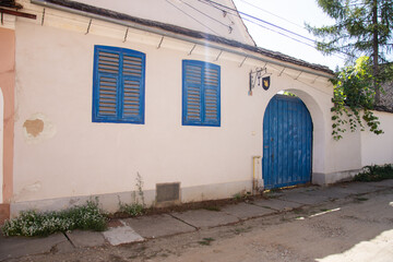  Biertan, Sibiu, Romania,the facade of a house with windows and blue gate