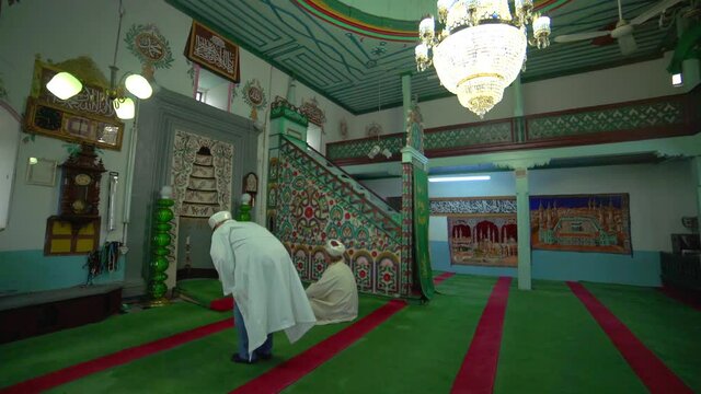 Muslim mosque teacher in a robe and turban at the small historic wooden masjid.Interior mystical people praying pray god religion mysterious religious islamism islam moslem place of worship prayer man