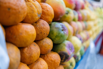 Close-up of a colorful fruit stand with tangerines and mangoes