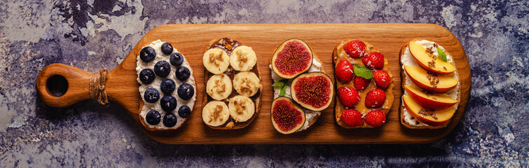 Homemade summer toast with cream cheese, nut butter and fruits and berries.