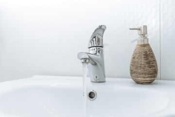 clean water flows from the tap. the water tap in the bathroom is turned on. water supply, utilities...