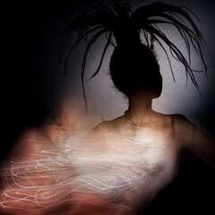A silhouette of a woman with a fancy hairstyle and shiny tracks from a necklace. Fashion...