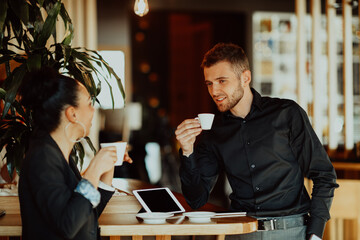 two young people on a break from work in a cafe take a break from everyday obligations.