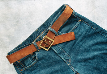 Blue mens denim pants, jeans, with a leather belt, fashion clothing concept. View from above with...