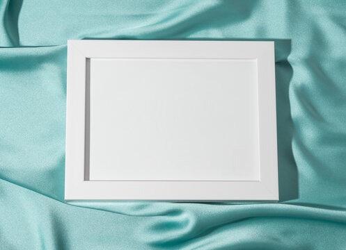White empty mockup frame for text or picture on green satin background