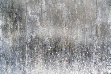 Fragment of a black metal wall. There are two joints between the steel sheets. The lower part is covered with mud. Background. Texture.