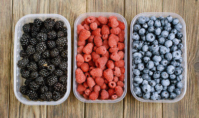 Set of berries in boxes blueberries, raspberries and blackberrie.
