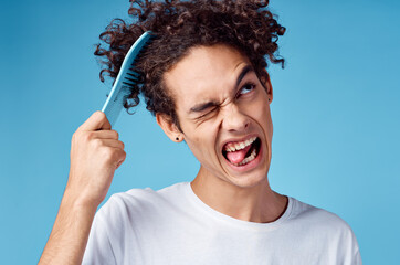 problems with combing hair young guy in t-shirt and combing curls model