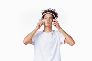 guy with curly hair and headphones white t-shirt light background close-up cropped