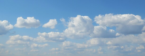 Panoramic view of fluffy clouds in blue sky, natural background 