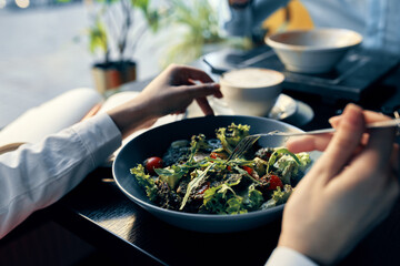 fresh salad in a plate delicious food diet fork in hand female hands cafe