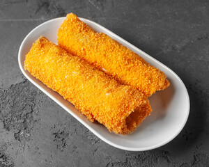 Sigara Boregi  Two Turkish Cigar Shaped Rolls on a white plate on a concrete background