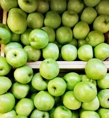 bright juicy green apples in a wooden box