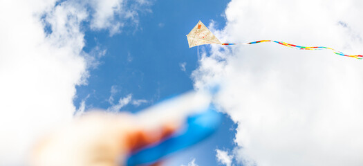 Self-painted kite flies against a blue sky. Creatively painted kite. Kite flying. Selbst bemalter...