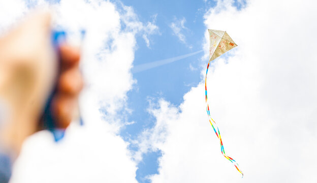 Selbst bemalter Drachen fliegt vor blauem Himmel. Kreativ bemalter Drachen. Drachen fliegen. Self-painted kite flies against a blue sky. Creatively painted kite. Kite flying.