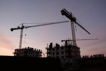 The construction site of a new housing estate - construction and cranes in the morning sun