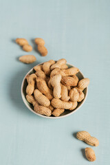 Pile of Peanuts in a bowl on a light blue background