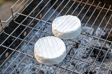Baked camembert cheese preparing on grill. Grilling at summer weekend. Delicious simple recipe for...