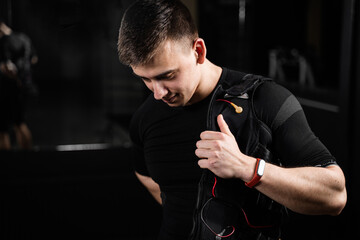 Wearing EMS suit in gym. Sport training in electrical muscle stimulation suit.