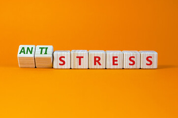 Antistress vs stress symbol. Turned cubes and changed the word stress to anti stress. Beautiful orange table, orange background. Medical, psychological, antistress vs stress concept. Copy space.