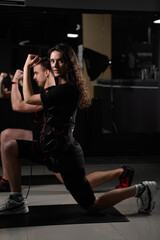 EMS group training for two men and women in the gym. Electrical stimulation for muscles of body.