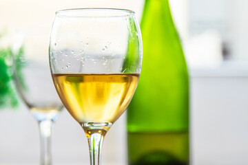 glass of white wine with bottle on table