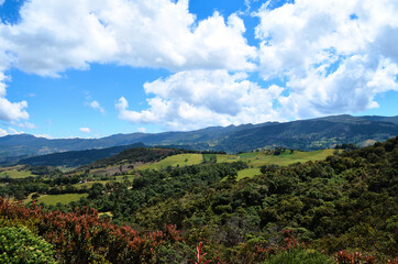 A view of the mountains, green foliage and blue sky at the natural park of Guatavita, located in...