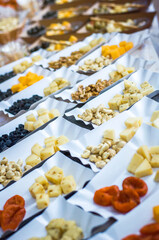 Obraz na płótnie Canvas Tasting Cheese at the Fair ( olives , honey, dried apricots, raisins, walnuts, cashews )