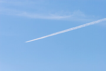 青い空と空を斜めに横切る白い飛行機雲