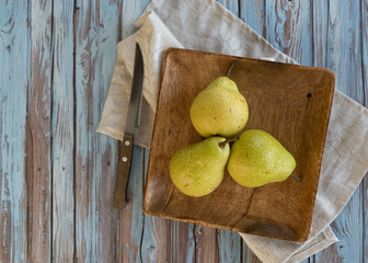 still life, three pears on a wooden plate in rustic style