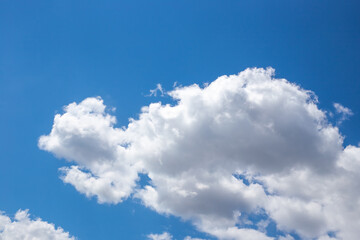Naklejka na ściany i meble White fluffy clouds against a blue sky. Airy clean natural background