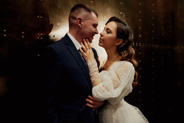 bridegroom and bride in a elegant dress in a dark corridor