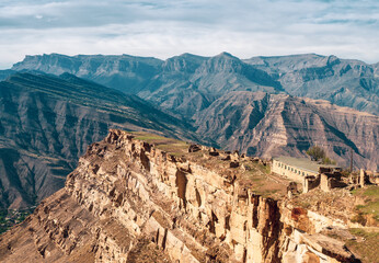 Summer view of ruins in the aul ghost Goor in Dagestan in the evening light. A stone building on a...