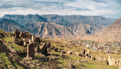 Summer view of ruins and towers of the aul ghost Goor in Dagestan in the evening light.