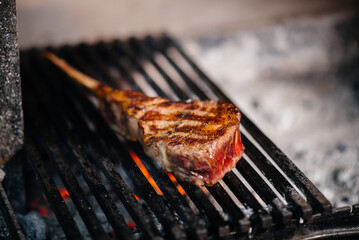 Juicy steak is grilled in a restaurant. Roasting meat in the fire on the grill.