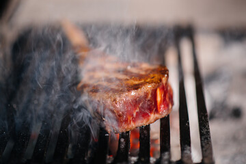 Juicy steak is grilled in a restaurant. Roasting meat in the fire on the grill.