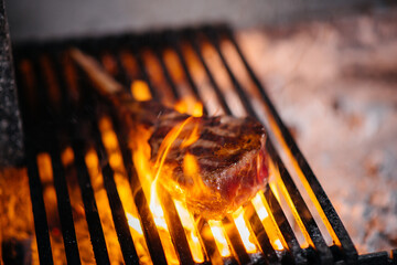 Juicy steak is grilled in a restaurant. Roasting meat in the fire on the grill.