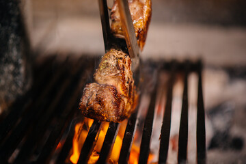 Juicy steak is grilled in a restaurant. Roasting meat in the fire on the grill.