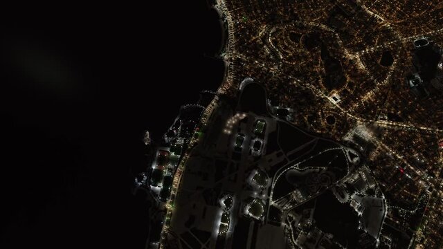 Coastline from above at night. Satellite view of a coastal road with city lights 