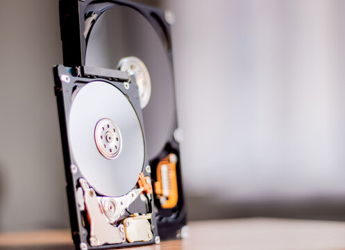 Disassembled hard drive from the computer with mirror effect. Opened hard drive from the computer hard disk drive (HDD)