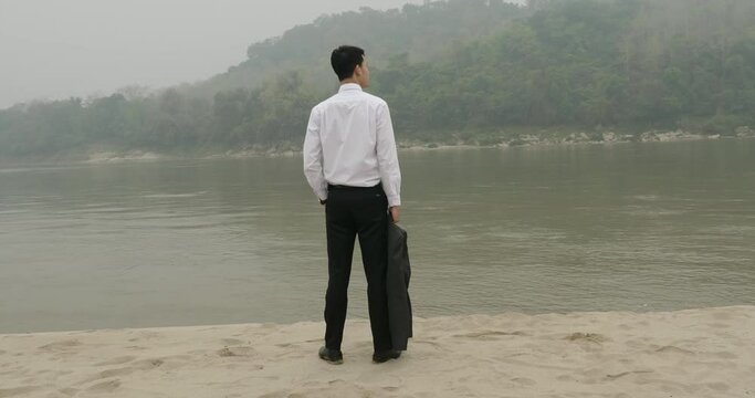 Businessman Standing Near River 
