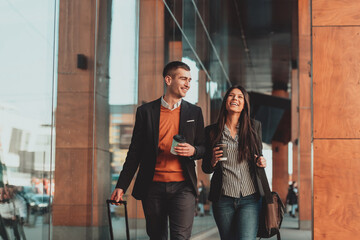 Business man and business woman talking and holding luggage traveling on a business trip